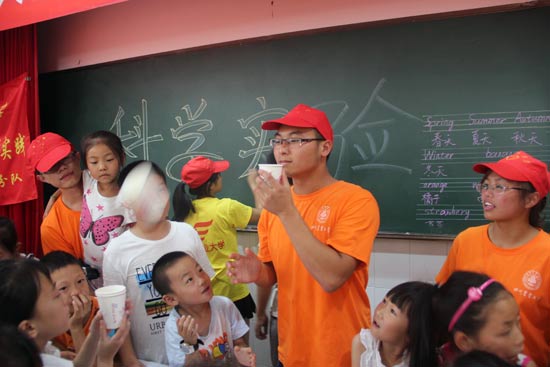 志愿者和小學生一起做科學實驗。