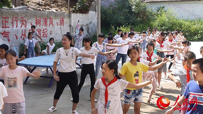 河南科技大學(xué)“一帶一路”義務(wù)支教與精準(zhǔn)扶貧調(diào)研實踐團(tuán)到河南宜陽縣香鹿山鎮(zhèn)磚古窯村開展義務(wù)支教和扶貧調(diào)研,圖為志愿者教孩子們太極拳。(團(tuán)隊提供)